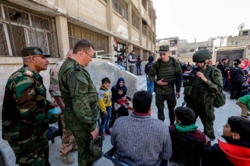 Soldados rusos y sirios con civiles evacuados de la zona de Guta (marzo, 2018)