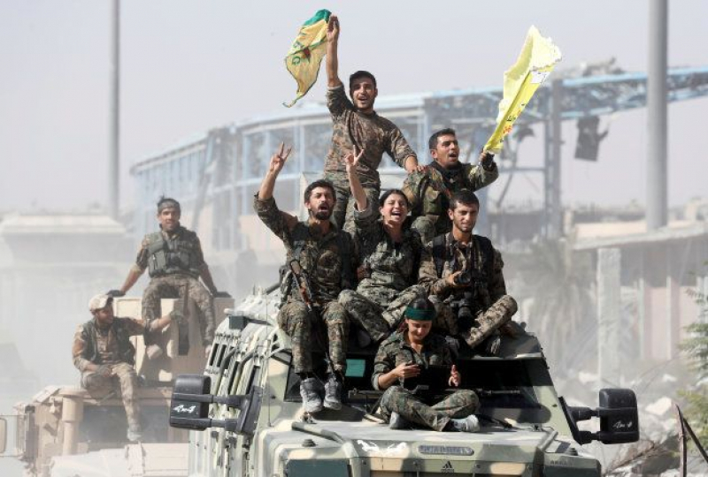 Miembros de las Fuerzas Democráticas de Siria, paseando triunfantes el pasado miércoles por las calles de Raqqa.