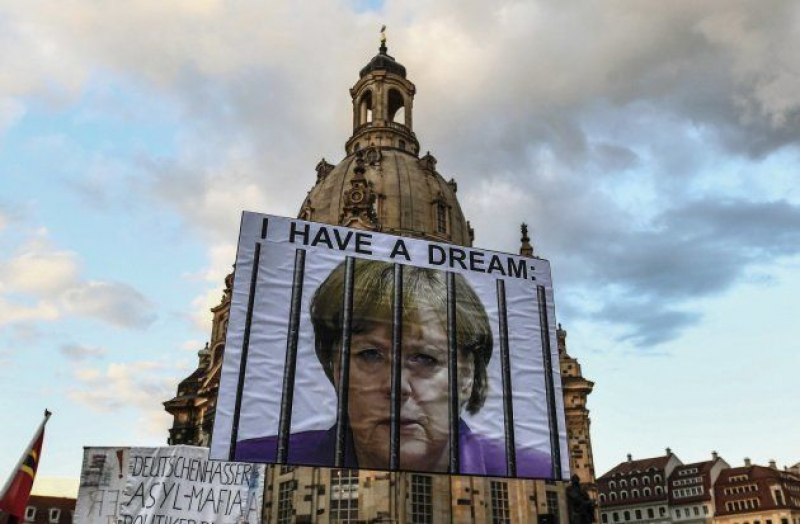 Vista de un cartel con la la líder de la Unión Cristianodemócrata (CDU), y canciller alemana, Angela Merkel encarcelada y con las inscripción 'I have a dream' (Tengo un sueño) durante una manifestación del movimiento islamófobo Pegida y d...