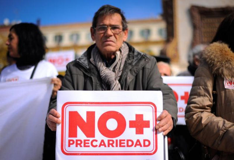 Un hombre sujeta una pancarta que dice 'No más precariedad' en una manifestación en Málaga.