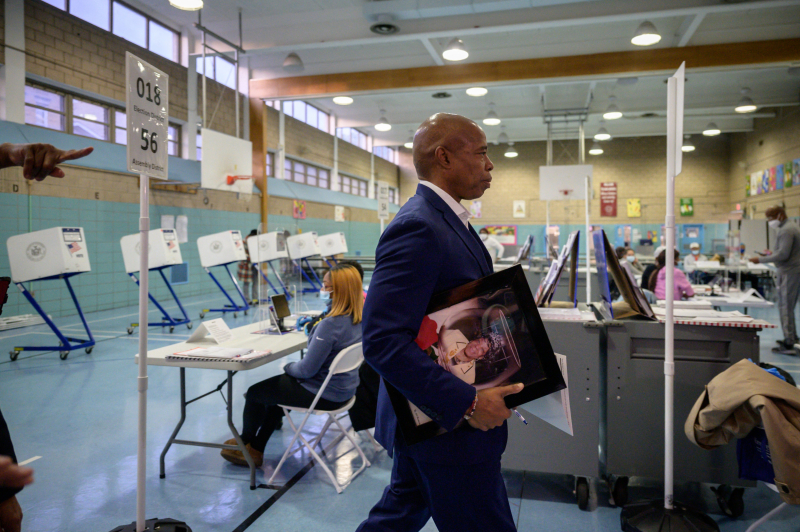 Eric Adams portando un retrato de su madre antes de emitir su voto.