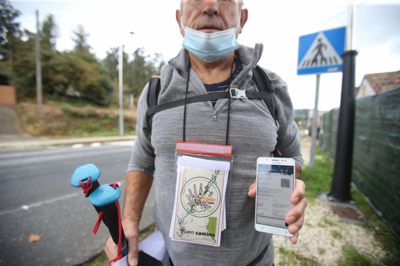 Un peregrino del Camino de Santiago muestra su pasaporte covid en O Pino, A Coruña, el 30 de octubre. Los albergues requieren ese certificado a los clientes.