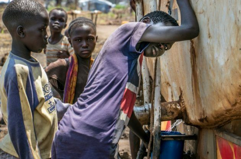 Niños recogiendo agua de uno de los camiones cisterna del campo de refugiados de Palorinya, en Uganda.