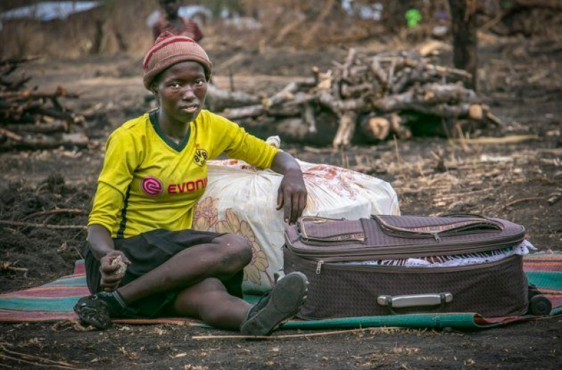 Una refugiada de Kajo Keju (Sudán del Sur) se sienta con su maleta en el campo de refugiados de Palorinya, Uganda.