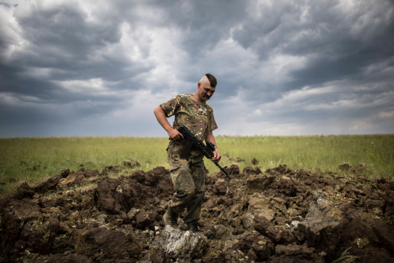 Un soldado ucraniano revisa un cráter tras un lanzamiento de cohetes en Toshkivka, Lugansk, en junio de 2015. 