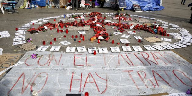 Detalle de las flores,zapatos y carteles en la acampada contra la violencia machista en la Puerta del Sol