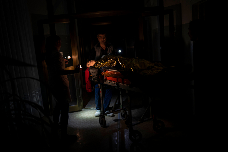 Un sanitario traslada a un quirófano a Arthur Voblikova, de 13 años, en un hospital de Jersón. El niño ha perdido un brazo y es atendido a oscuras por la falta de medios. 