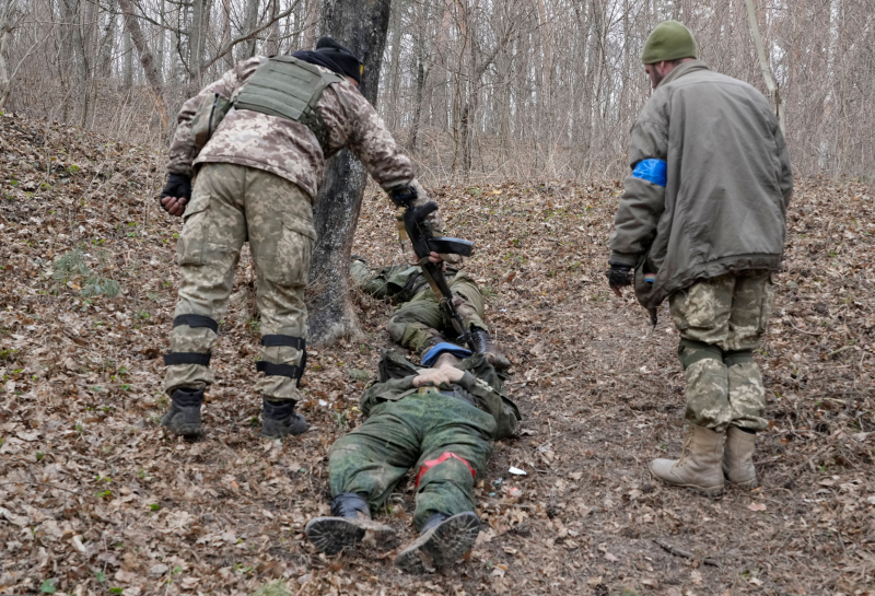 Soldados ucranianos revisan los cuerpos de unos uniformados rusos en la villa de Trostsyanets, a 400 kilómetros de Kiev, el pasado 28 de marzo.