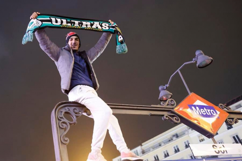 Un seguidor marroquí se encarama a lo alto de la estación de Sol con una bufanda con la leyenda 'Ultras'