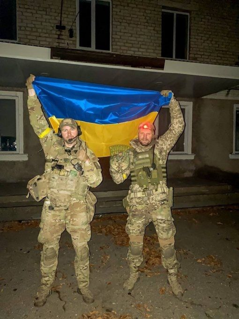 Dos integrantes de la Unidad Carlson, con la bandera ucraniana.