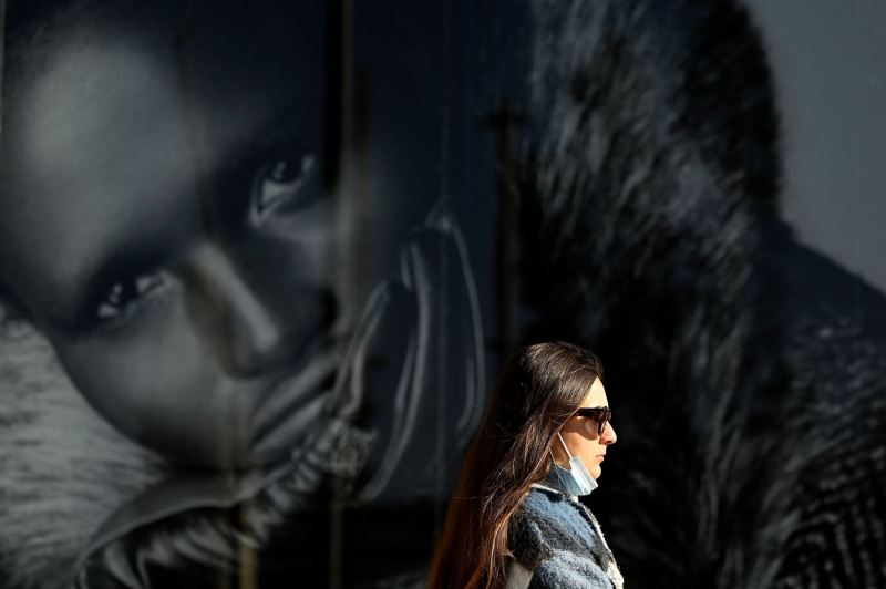Una mujer pasea por la calle con la mascarilla bajada en Madrid, el 27 de enero de 2022.