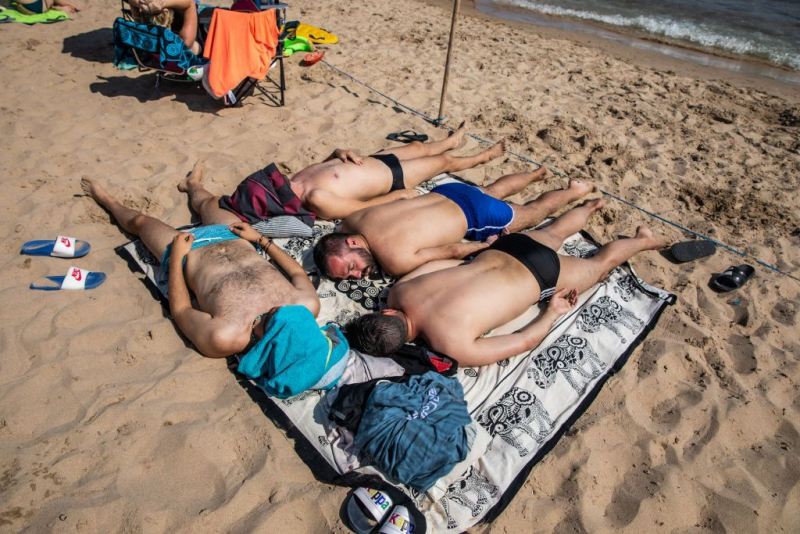 Cuatro turistas en la playa de Benidorm, en julio.
