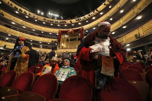 The one known as 'Mocito Feliz' (d), along with other people dressed up, waits inside the Teatro Real